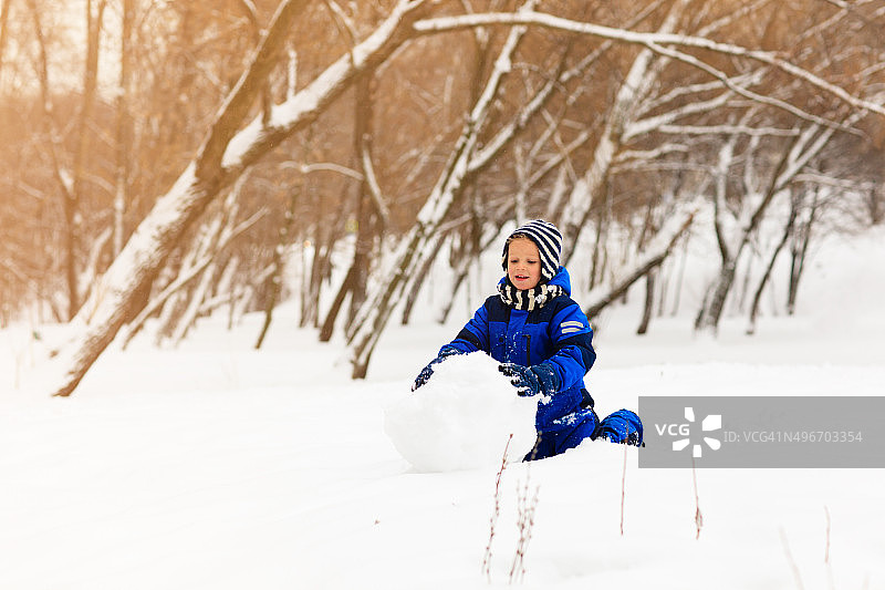 冬天堆雪人的可爱小男孩图片素材