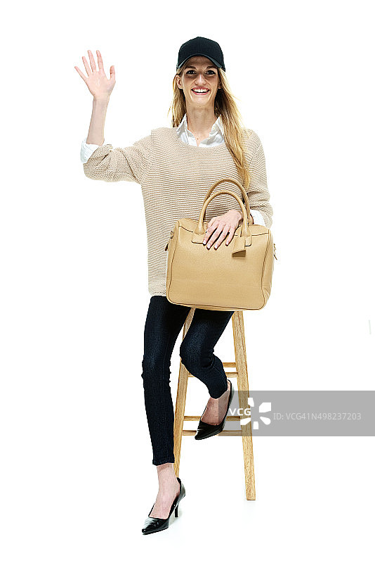 坐在凳子上挥手的快乐女人图片素材