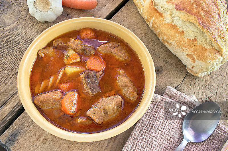 木质背景上的陶瓷碗炖猪肉图片素材