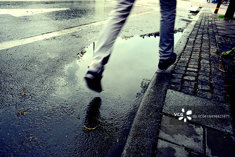 行人跳过水坑图片素材