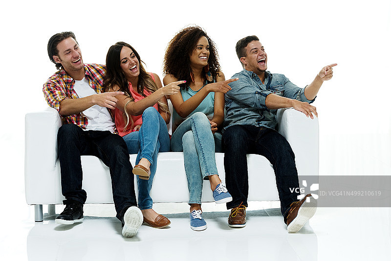 坐在沙发上指向远方的快乐潮人图片素材