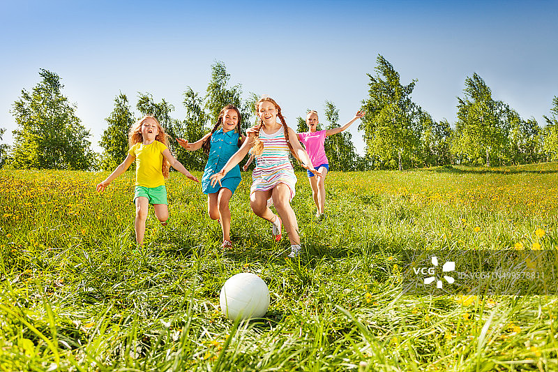 一群孩子在草地上奔向球图片素材