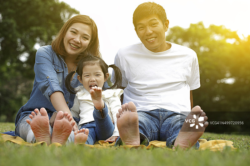 户外赤脚而坐的幸福家庭图片素材