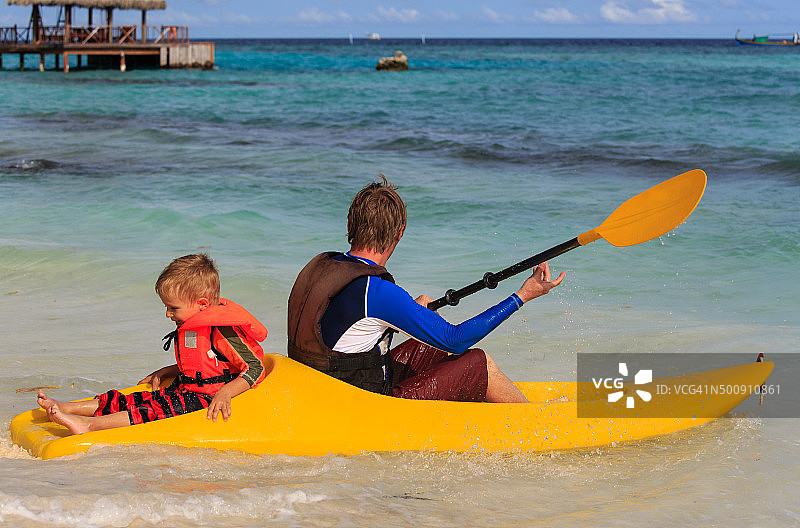 父子在热带海洋划皮划艇图片素材