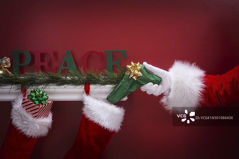 圣诞老人把手枪放在圣诞袜旁边图片素材