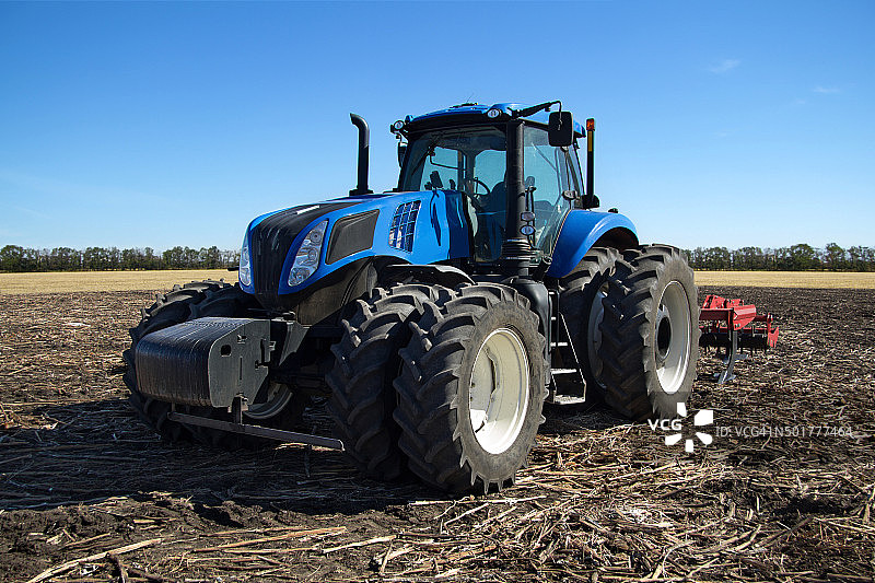 带犁的蓝色拖拉机图片素材