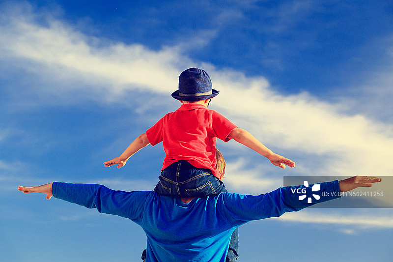 快乐的父子在天空玩耍图片素材