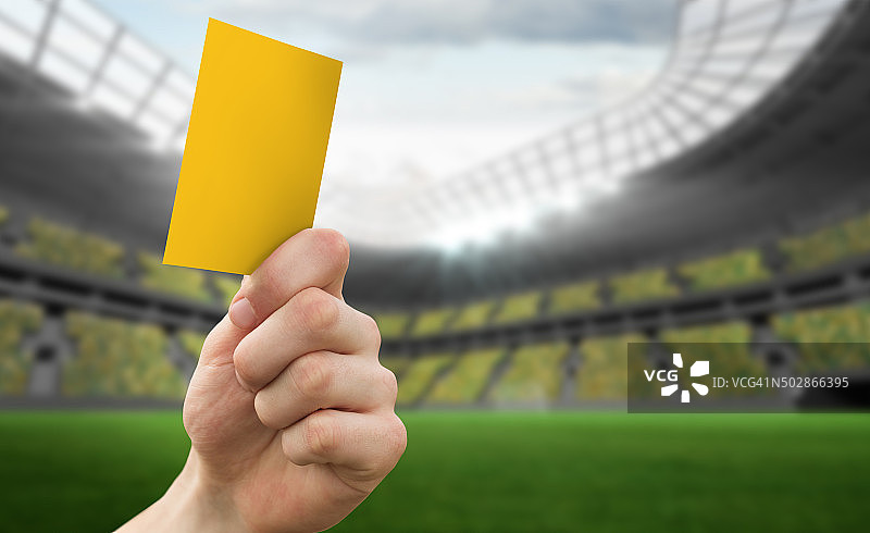 举起黄牌的手的合成图像图片素材