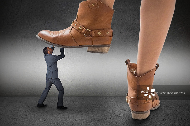 牛仔靴踩在商人身上的合成图像图片素材