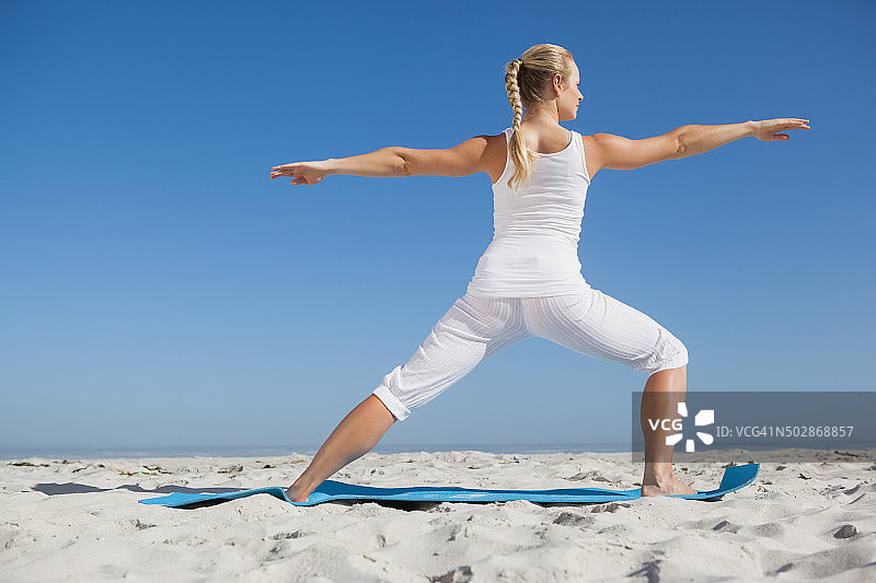 海滩上摆战士姿势的平静女人图片素材