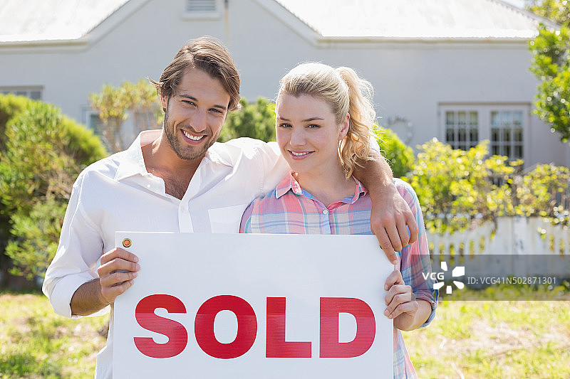 情侣在花园里拿着已售出的牌子图片素材