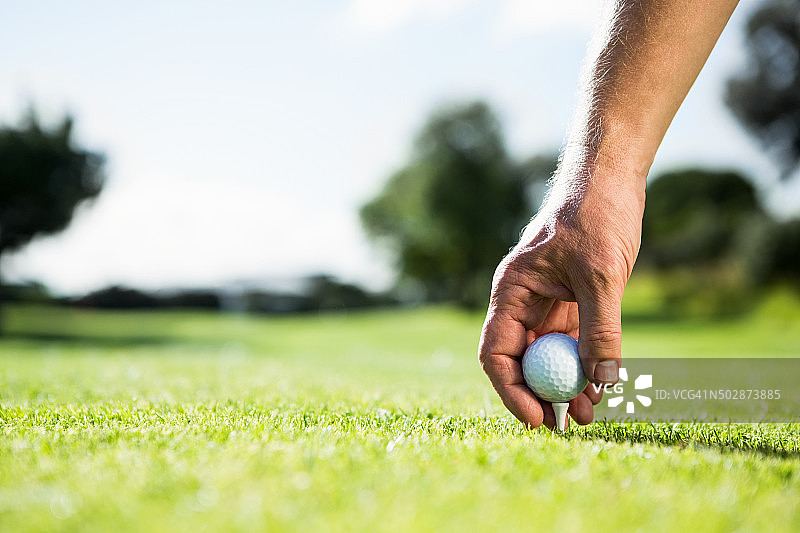 高尔夫球手将高尔夫球放在球座上图片素材