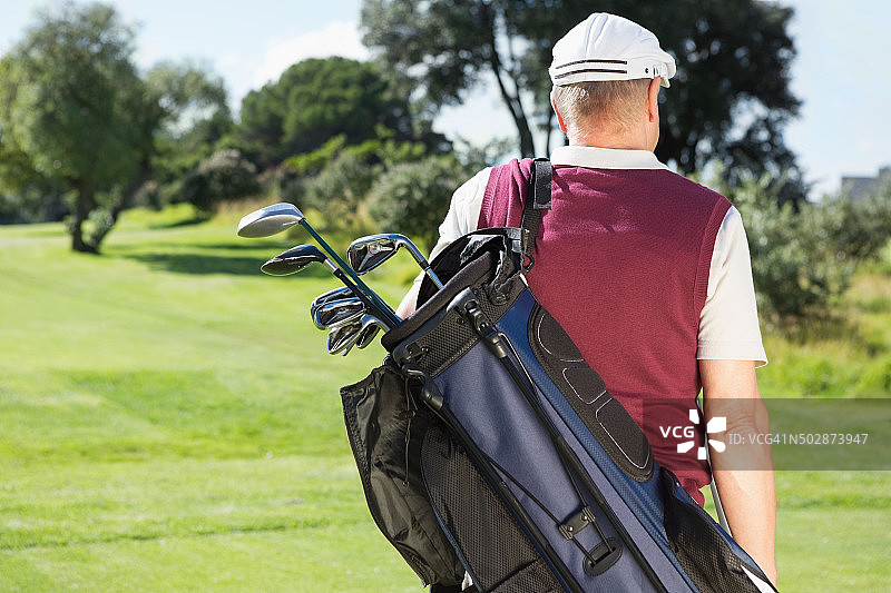 高尔夫球手拿着他的高尔夫球包图片素材