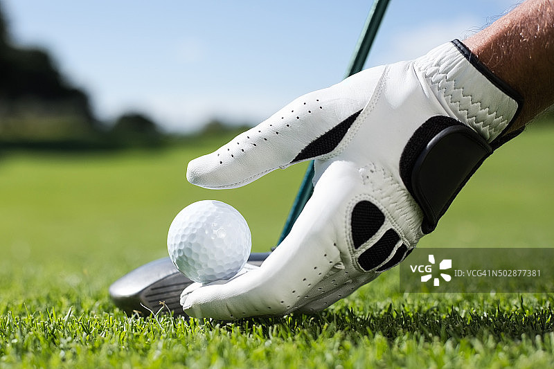 高尔夫球手将高尔夫球放在球座上图片素材