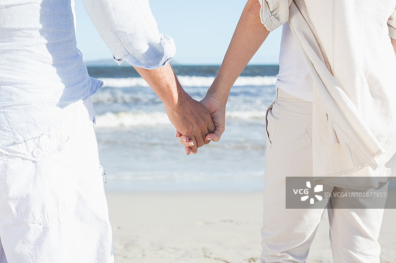 在海滩上手牵手眺望大海的情侣图片素材