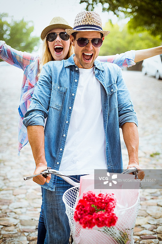 时髦的年轻夫妇骑自行车兜风图片素材