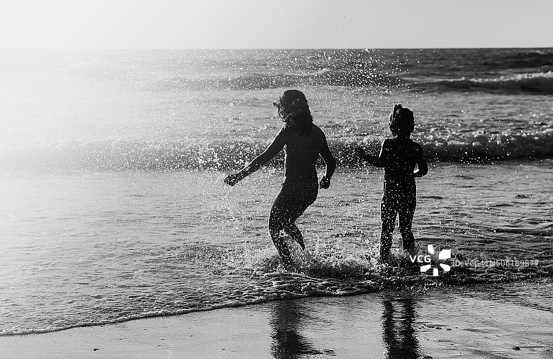 在海滩上玩耍的两个快乐儿童图片素材