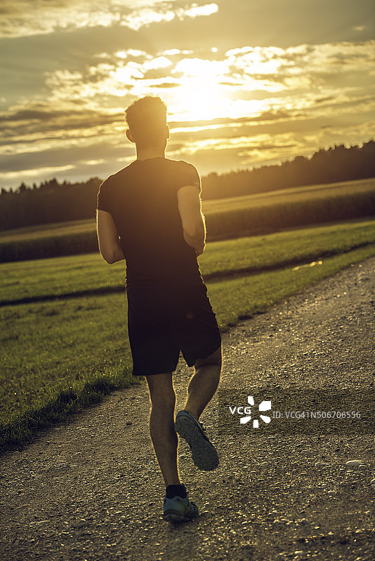 男人朝着日落奔跑的背影图片素材