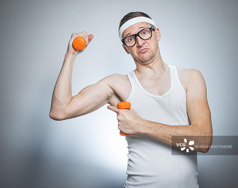 趣味瘦弱男子展示肱二头肌图片素材