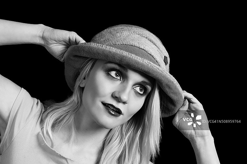 黑白照片：金发女子拉着冬帽，看向远方图片素材