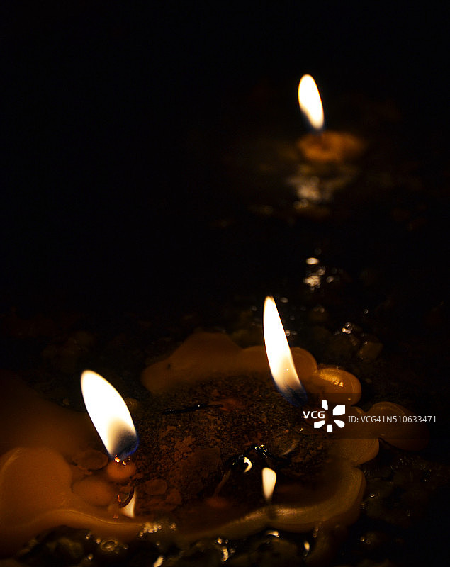 深色背景下教堂里燃烧的蜡烛图片素材