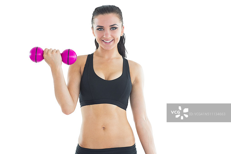 快乐的活跃女人用哑铃训练，对着镜头微笑图片素材