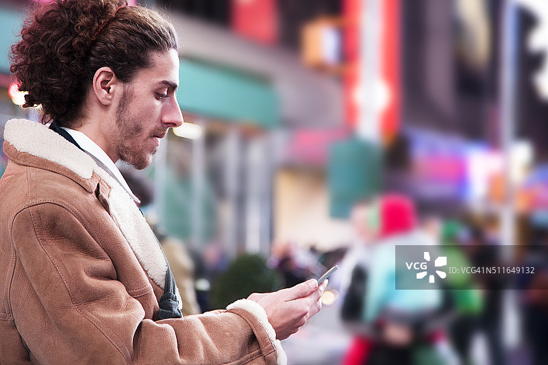 男子在纽约时代广场手拿手机图片素材