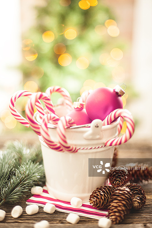 木桌上的白色小桶里的拐杖糖图片素材