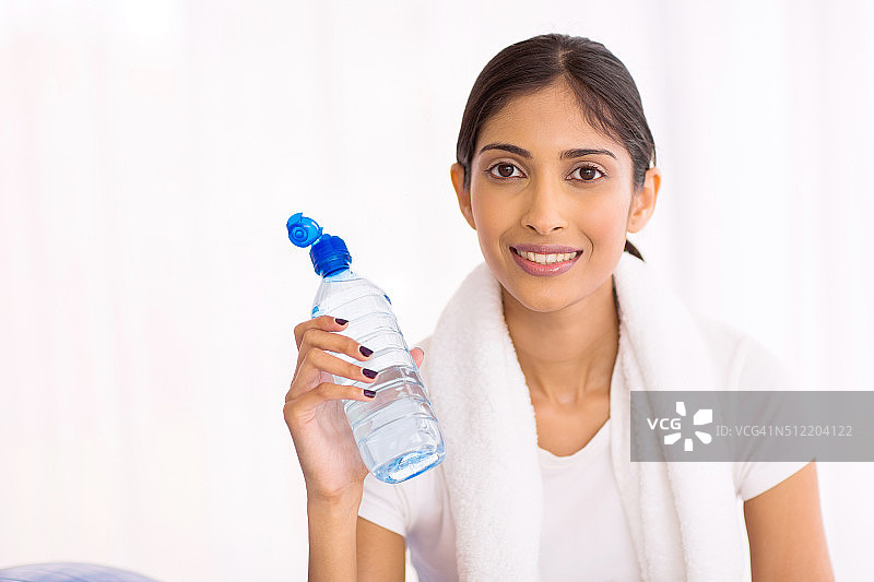 年轻的印度妇女运动后喝水图片素材
