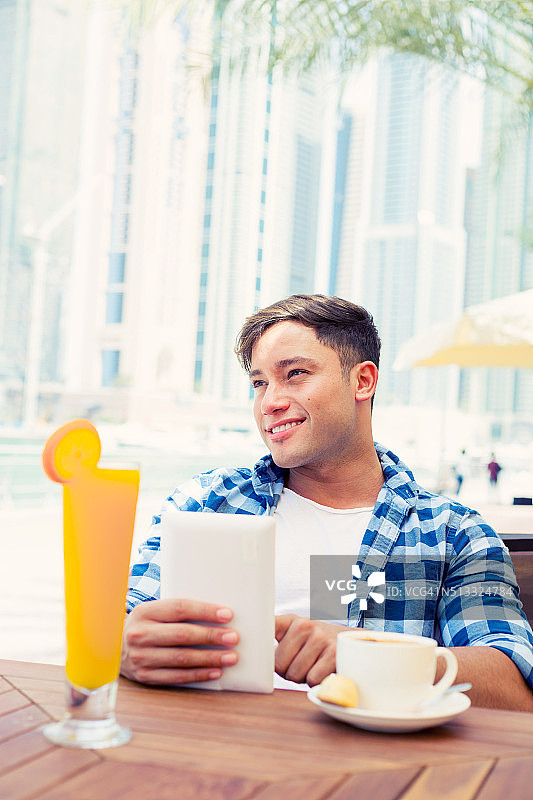 在迪拜码头喝新鲜咖啡的年轻男人图片素材