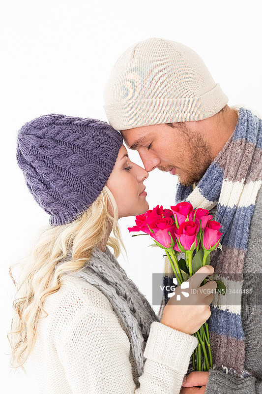 穿着暖和的衣服拿着鲜花，有吸引力的情侣图片素材