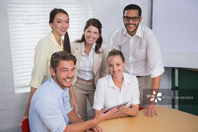 会议中笑容满面的商务人士使用平板电脑图片素材