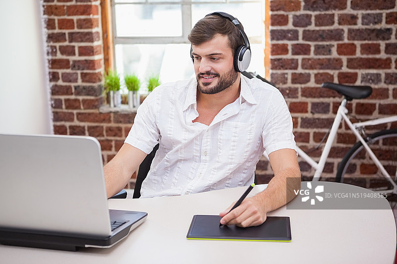 休闲设计师使用绘图板和笔记本电脑图片素材