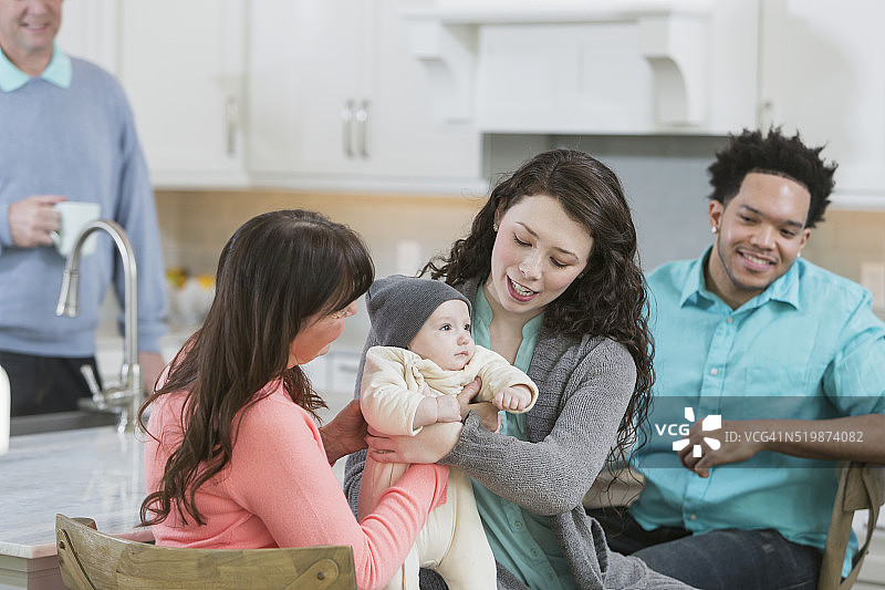 母亲抱着婴儿，祖母在一旁帮忙图片素材
