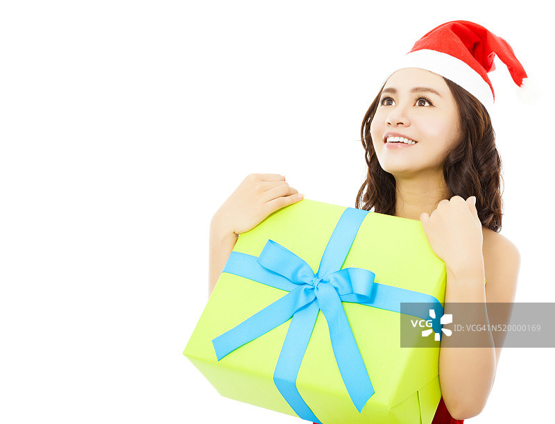 拿着圣诞礼盒向前看的年轻微笑女人图片素材
