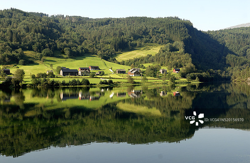 哈当厄尔峡湾中倒映的农场村庄图片素材