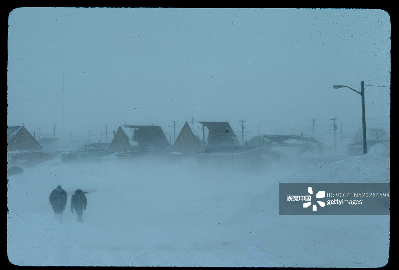 暴风雪中的村民和建筑物图片素材