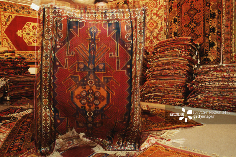 男人举着东方地毯图片素材