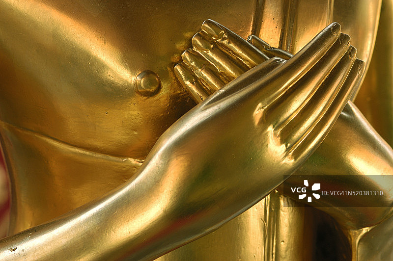 放在金色雕像上的手图片素材