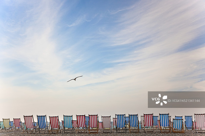 西德茅斯鹅卵石海滩上的躺椅图片素材