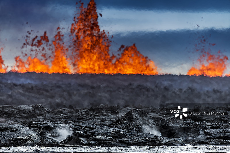 冰岛巴达本加火山附近的霍卢赫劳恩裂缝喷发出的热气腾腾的熔岩和羽流图片素材