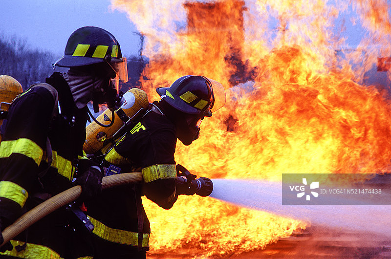 消防员用软管扑灭火焰图片素材