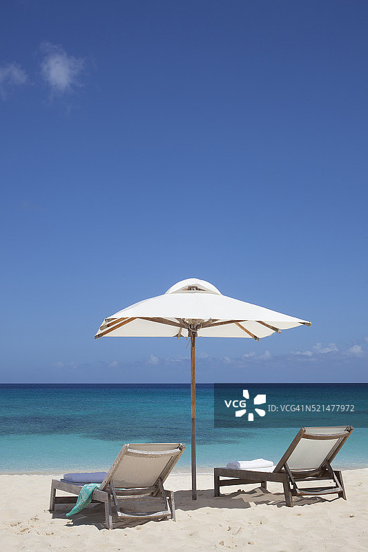 海滩上的两把躺椅和遮阳伞图片素材