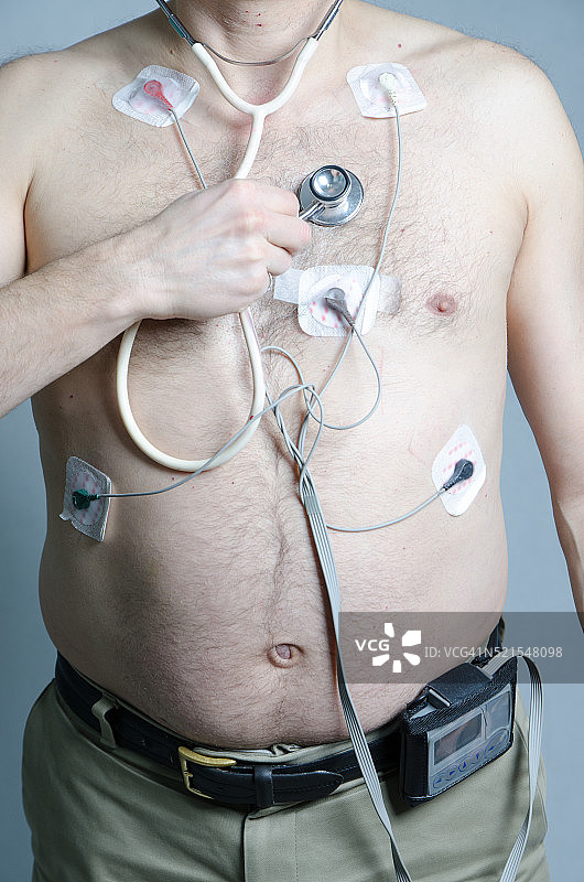 佩戴动态心电监护仪和5个传感器的50岁男人图片素材