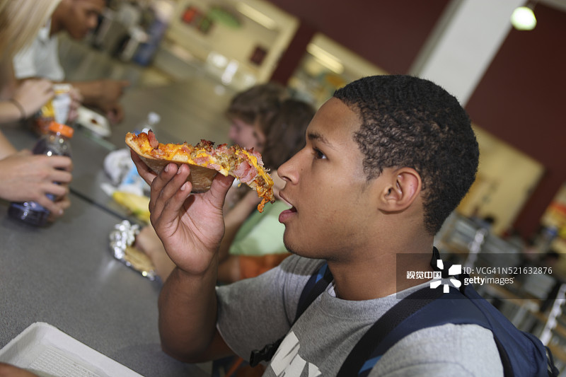 高中生在学校食堂吃披萨图片素材