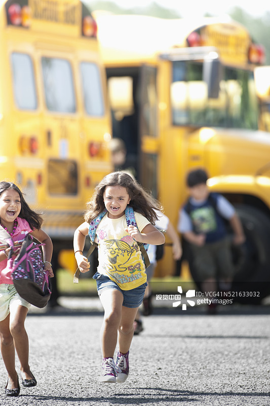 在校车附近奔跑的小学生图片素材