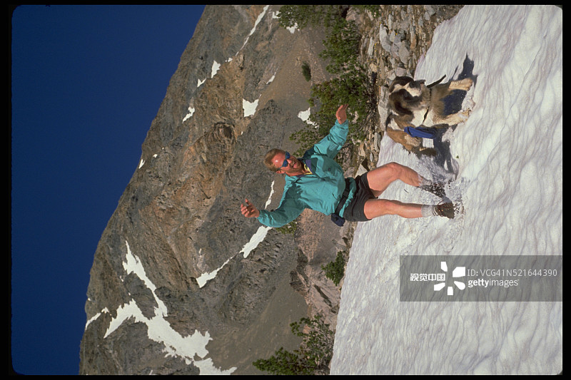 登山者和圣伯纳犬在爱达荷州太阳谷附近的雪地上滑行图片素材
