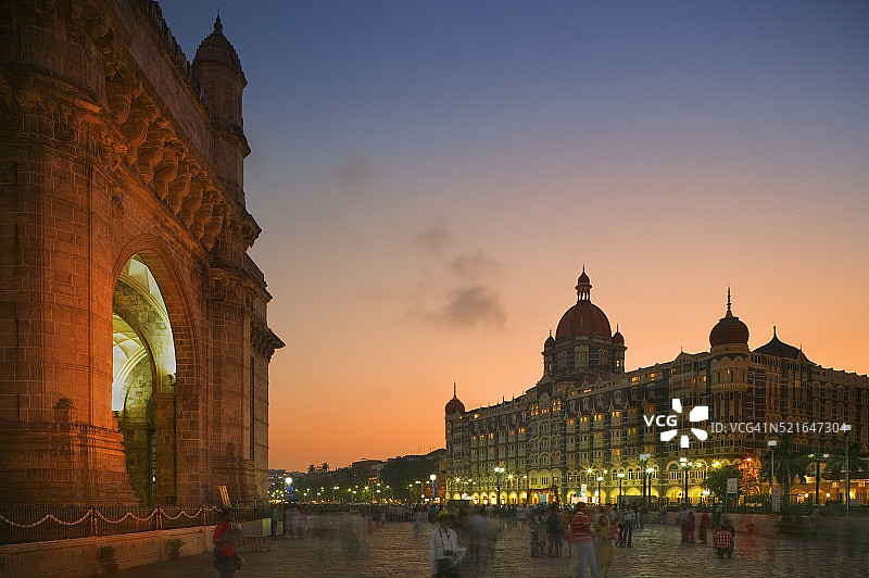 人们在印度门和泰姬陵皇宫酒店之间漫步图片素材