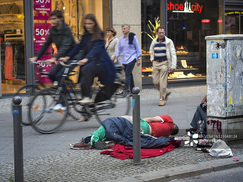 一个醉酒的男人躺在弗里德里希大街上图片素材