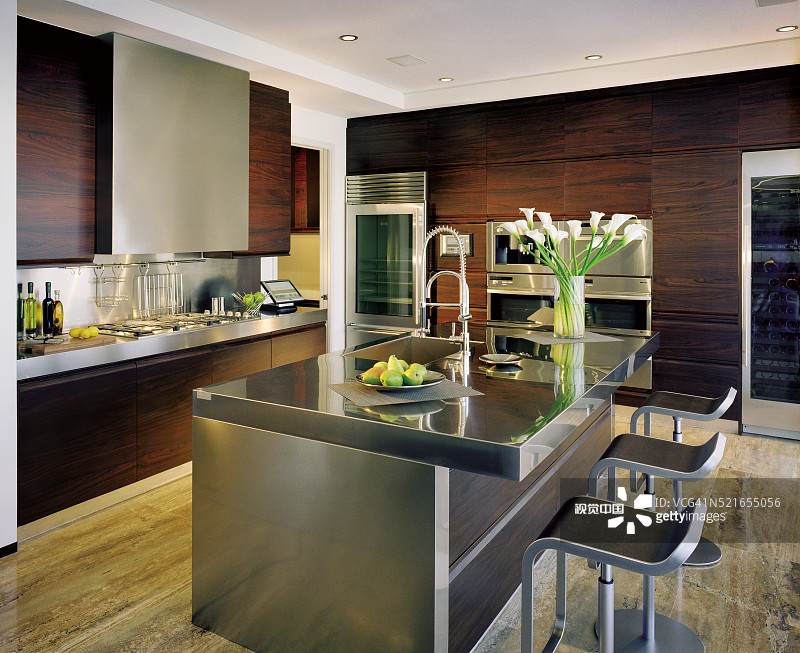 三个时尚的凳子放在一间不拘一格的厨房的柜台附近图片素材